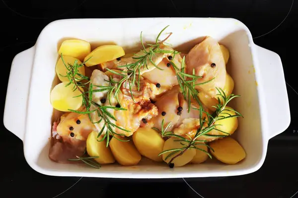 Raw chicken with lots of potatoes prepared for roasting. Home cooking concept. High quality photo