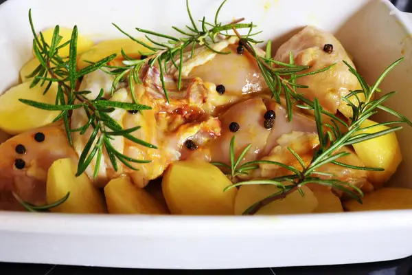 Raw chicken with lots of potatoes prepared for roasting. Home cooking concept. High quality photo