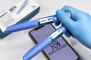 Elleri mavi cerrahi eldivenli, diyabet hastaları için Ozempic insülin enjeksiyon kalemi tutuyor. Danimarka - 1 Şubat 2024.