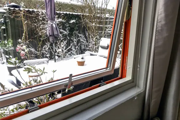 Open window on a winter day. Winter and snow outside the window in the garden. High quality photo