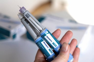 Hand holding Ozempic Insulin injection pen for diabetics. Denmark - March 25, 2024 clipart