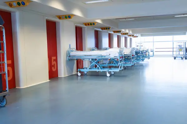 Clean hospital beds covered with film, ready for new patients. Hospital and nursing concept.