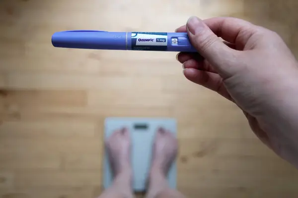  Şeker hastaları ve kilo kaybı için Ozempic insülin enjeksiyon kalemi. Kadın tartılıyor ve Ozempic 'i elinde tutuyor. Kilo verme konsepti. Danimarka - Haziran 01, 2024