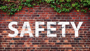  SAFETY on dark texture of old red bricks wall background