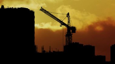 Siluet 'te Büyük Kule Turna ile inşaat alanı, Parlak bir akşam gökyüzünün huzurunda