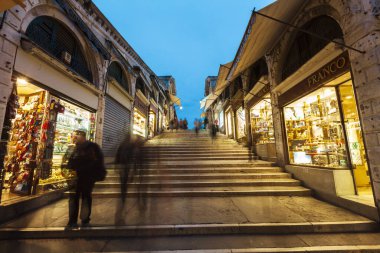 Venedik, Veneto, İtalya - 14 Kasım 2013: Mavi saatte Venedik sokaklarında yürüyüş. Venedik 'teki meşhur Rialto köprüsünün içeriden görünüşü.