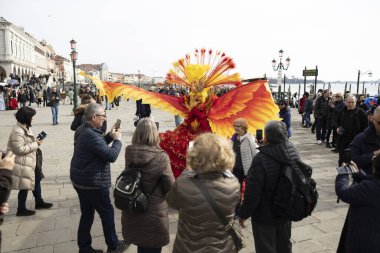 Venedik, Veneto, İtalya - 19 Şubat 2020: Venedik 'teki San Marco Rıhtım kaldırımında 2020' deki geleneksel karnaval sırasında fotoğrafçılar ve normal insanlar şehrin en iyi Venedik Maskelerini fotoğraflamaya çalışırken