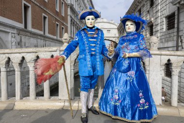 Venedik, Veneto, İtalya - 19 Şubat 2020: Mavi Renkli Maskeli Güzel Venedik Karnaval Çifti Arka planda İç Çekiş Köprüsü ile Venezia Ünlü Rıhtımı 'nda poz veriyor