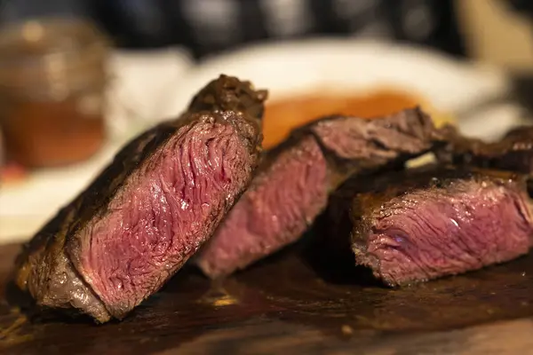 stock image Cut Grilled Beef Steaks on Wooden Plate