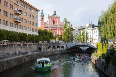 Ljubljana, Slovenya - 13 Ağustos 2021: Turist tekneleri, kanolar, kürekçiler ve özellikle yazın eğlence ve turizm amaçlı Ljubljanica nehri.