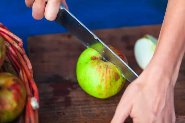 Hands Split Cut an Apple Close up on Wood