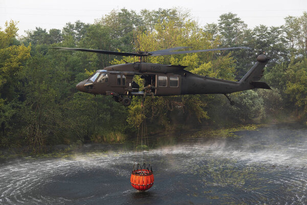 Miren, Nova Gorica, Slovenia - July 21, 2022: Slovak Air Force Helicopter Helps Slovenian Firefighters Extinguishing the Extensive Fire in the Slovenian Italian Area of Karst. Here Loading Water from Vipava River in the Suburbs of Miren Town
