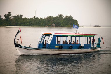 Bathala Adası, Maldivler - 27 Ekim 2009: Tipik bir Maldivli balıkçı teknesi ve turist teknesi Dhoni bir ada tatil köyünün önünde konukların bulunduğu.