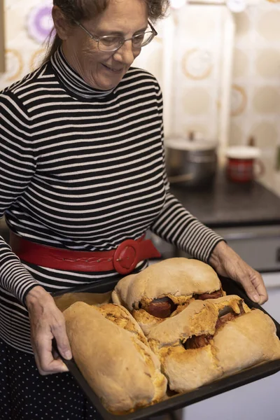 Senior Woman baking Prosciutto in Bread for Easter holiday Traditional gourmet