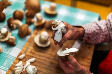 Housewife Scenting Fresh Mushrooms While Preparing them for Dinner