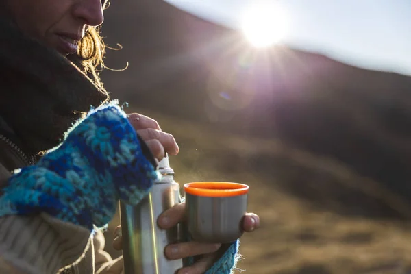 Hot Drink From A thermos For Woman Winter Hiker at Sunrise