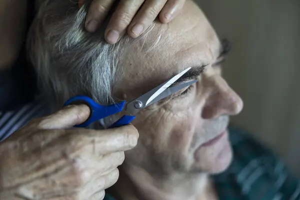 Eyebrow Trimming Close Up for a Senior Man