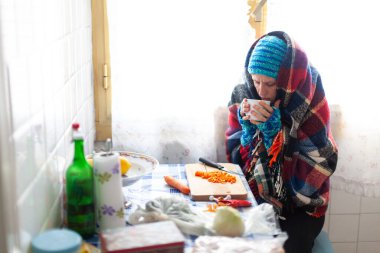 Yetişkin Kadın Yoksulluk Sosyal Sorunları adlı eski bir soğuk apartmanda kendine fakir menüsü hazırlıyor.