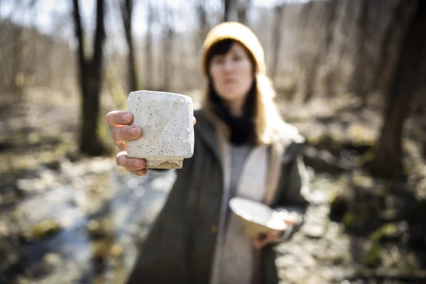 Young Woman Ceramic Artist with her crafted products in hands outdoors