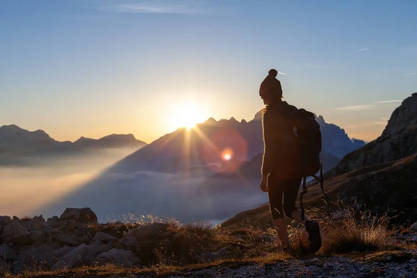 Woman Hiker Embarking on an Autumn Vacation Adventure, Journeying on the Footpaths of Julijana Trail in the Julian Alps, Slovenia, Bathed in the Warm Lights of Sunset above the European Alps Mountains