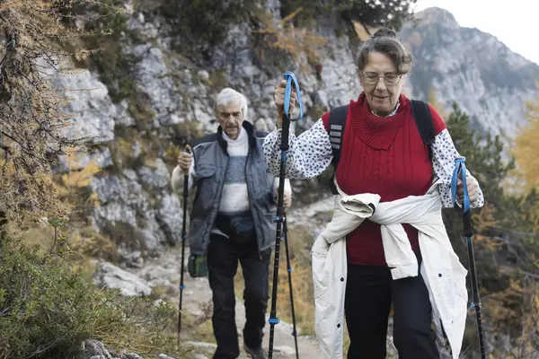 Front View of Senior Couple Active Lifestyle on Mountain Trekking in Autumn
