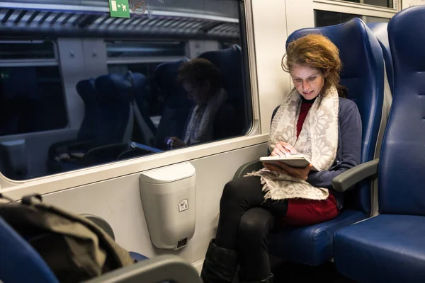 Adult Woman Reading on a Tablet While Travel With a Train