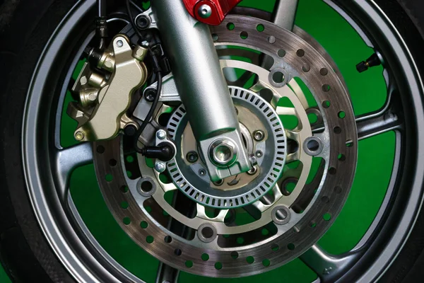 Motorcycle Disk Breaks and Front Wheel Close up on Green Background