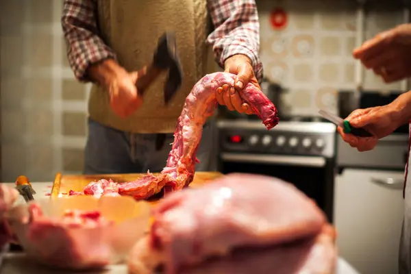 Senior Couple Cutting Whole Turkey in Domestic Kitchen Close up on Hands