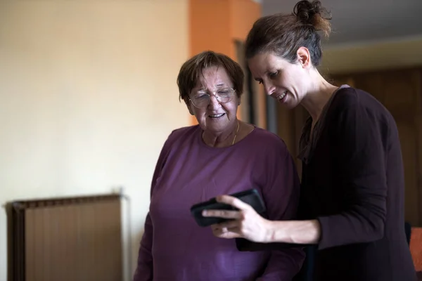 Mid Adult Daughter Helps Senior Mother to Understand Functions on a Smart Phone