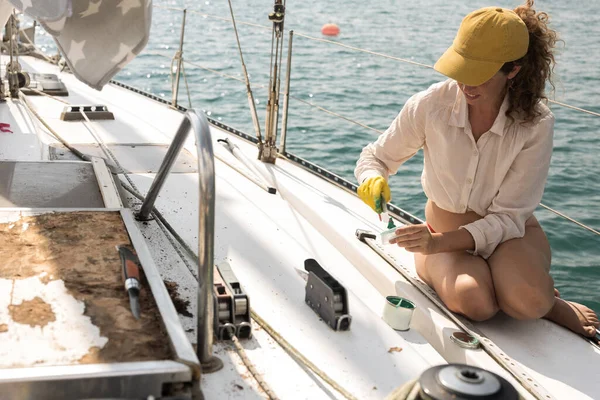 Repairing and Restoring a sail boat on the sea by Serene Adult Woman Expertise