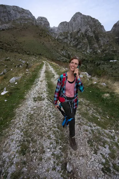 Taking a call after hike at home to communicate that everything is OK by Serene Female Caucasian Hiker