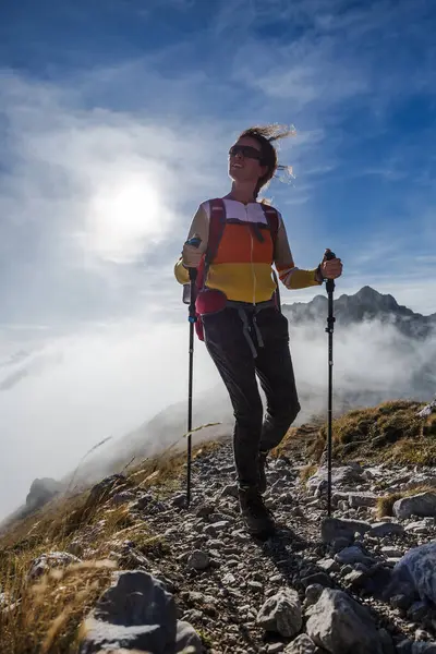 Adult Woman Climber Ascent Hike on European Alps Mountain on a Variable Weather