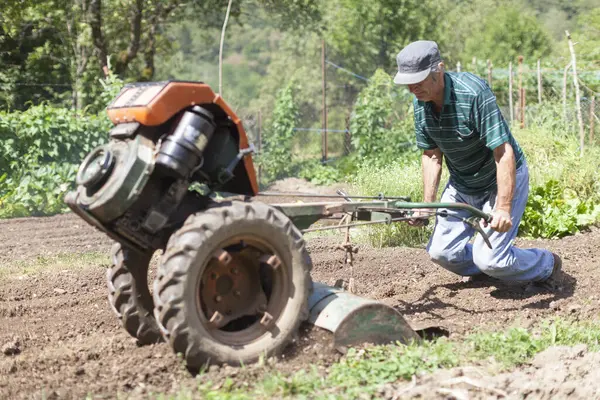 Starszy Rolnik Uprawiający Swój Ogród Domowy Pomocą Silnika Tiller — Zdjęcie stockowe