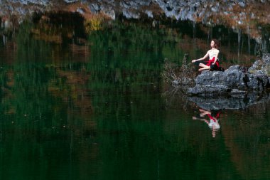 Kafkas Yetişkin Kadın Meditasyonu ve bir Dağ Gölü Huzur Mekanı Sahili 'nde dinlenme - Fusine Gölleri, Tarvisio, İtalya