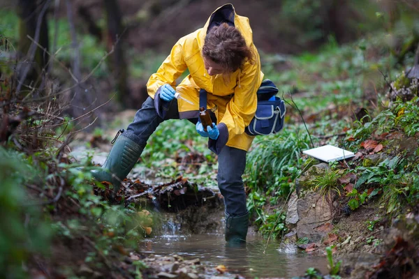 Střední Dospělý Biolog Sbírající Vzorky Vody Pro Další Zkoumání Potoka — Stock fotografie