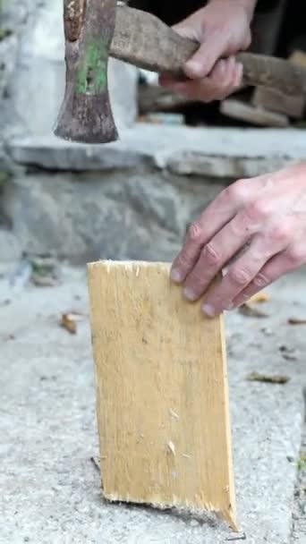 男性の手は 暖炉の垂直ビデオのためのイグニッション火災材料を生成するためのハチェット付きの小さなピースで速い木を切断 — ストック動画
