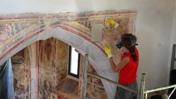 教会の壁に特別な化学応用プロセスを復元する 古代フレスコ 働いている間に保護ガスマスクを身に着けているプロフェッショナルな女性の復元者 — ストック動画