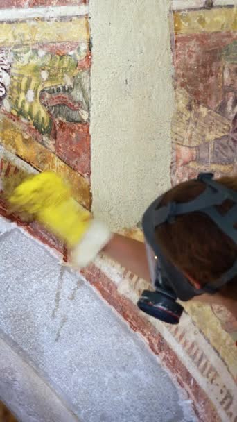 教会の壁に特別な化学応用プロセスを復元する 古代フレスコ 働いている間に保護ガスマスクを身に着けているプロフェッショナルな女性の復元者 — ストック動画