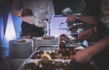 Şef mutfakta çalışıyor. Elleri ve tabakları kapatın..