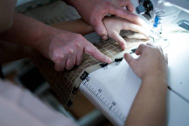 Terzi dükkanında çalışıyorum. Dikiş makinesi.