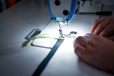 Terzi dükkanında çalışıyorum. Dikiş makinesi.