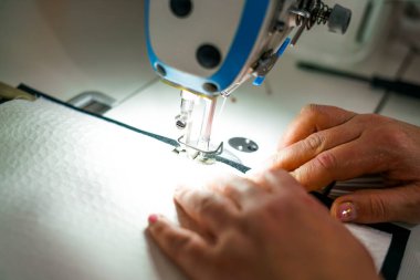 Terzi dükkanında çalışıyorum. Dikiş makinesi.