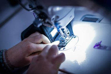 Terzi dükkanında çalışıyorum. Dikiş makinesi.