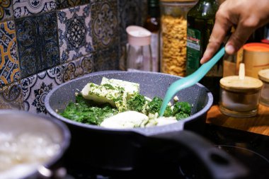 Mutfaktaki tavada taze ıspanak hazırlıyorum. 