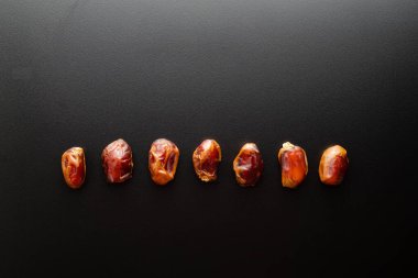Siyah arkaplandaki tarihlerin üst görünümü, sağlıklı yiyecekler