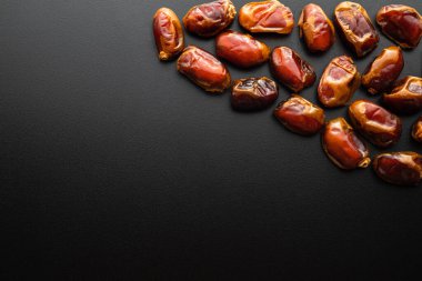 Siyah arkaplandaki tarihlerin üst görünümü, sağlıklı yiyecekler