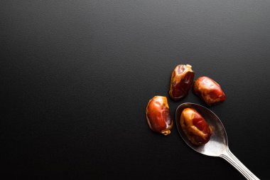 Siyah arkaplandaki tarihlerin üst görünümü, sağlıklı yiyecekler