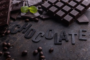 Dark, milk and nut chocolate bars. Crumbled on scattered cocoa.