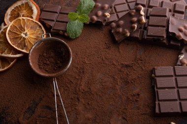 Dark, milk and nut chocolate bars. Crumbled on scattered cocoa.