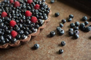 Taze meyveli tart. Ahududu ve üzümlü tart. Kırsal bir zeminde tatlı bir tatlı